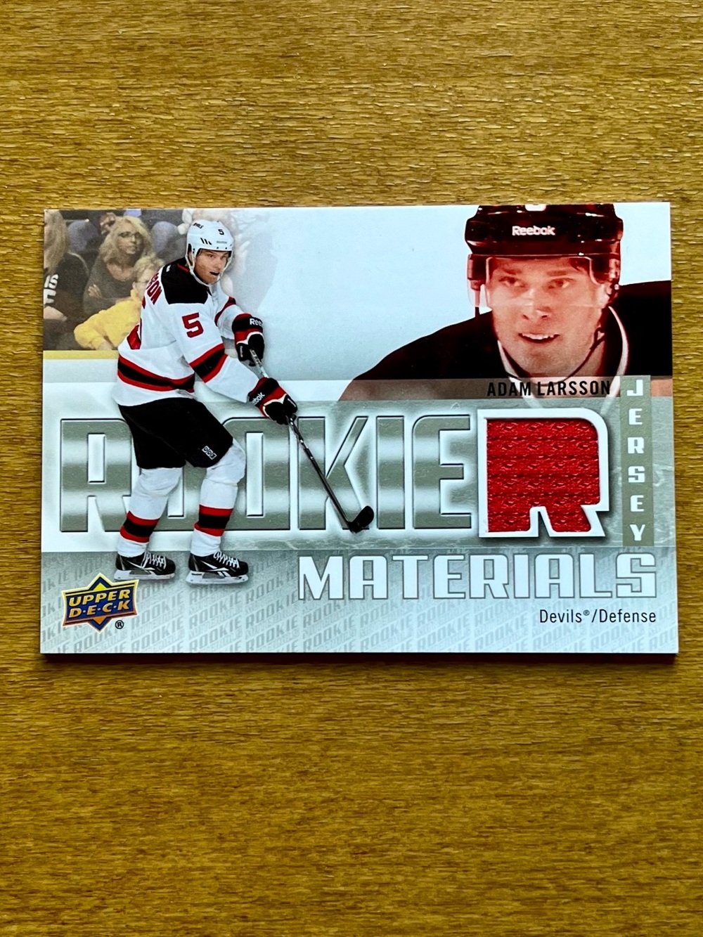 2011-12 UD Adam Larsson Rookie Materials Hockey Card with Red Jersey Swatch
